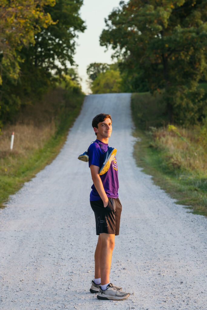 High school senior runner portraits on country road with cross country shoes
