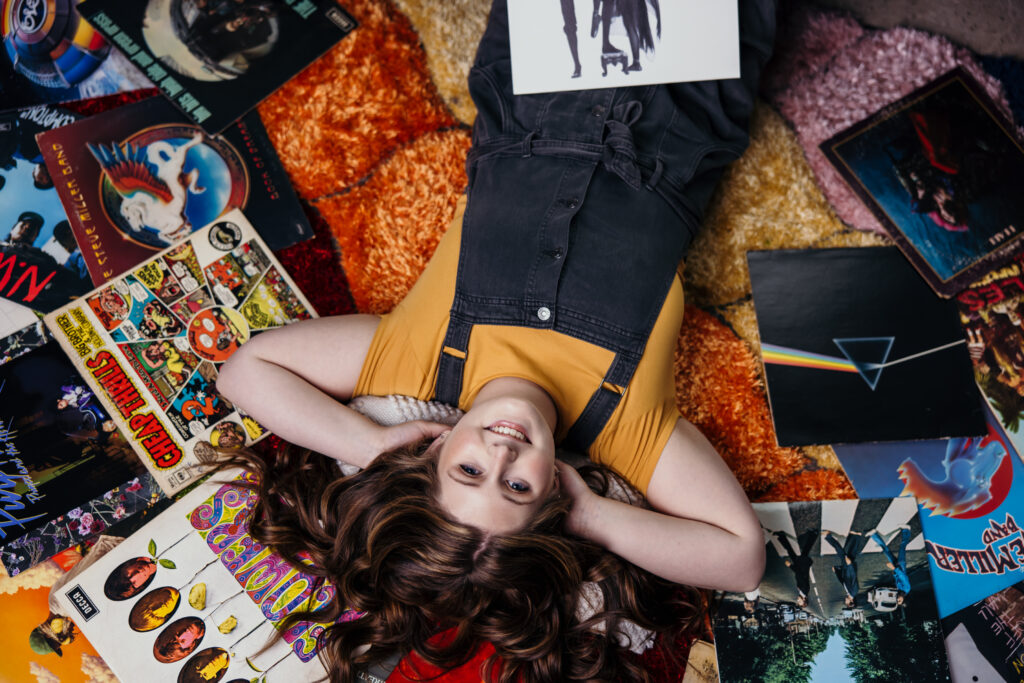 Music inspired senior portraits featuring senior girl with records