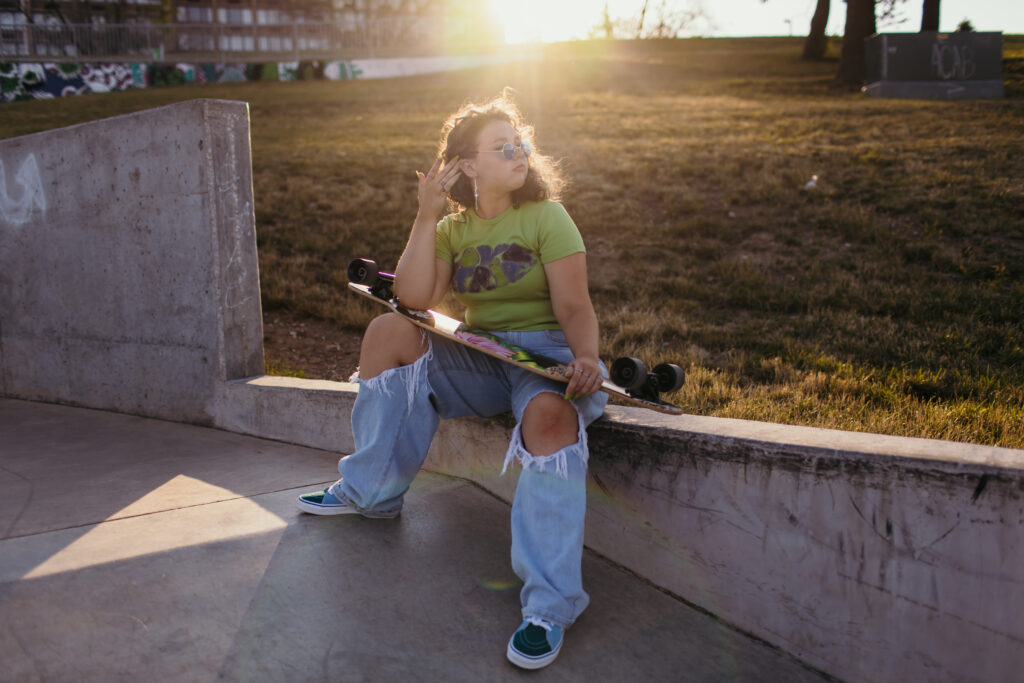 Kansas City senior girl at skate park with skateboard during golden hour
