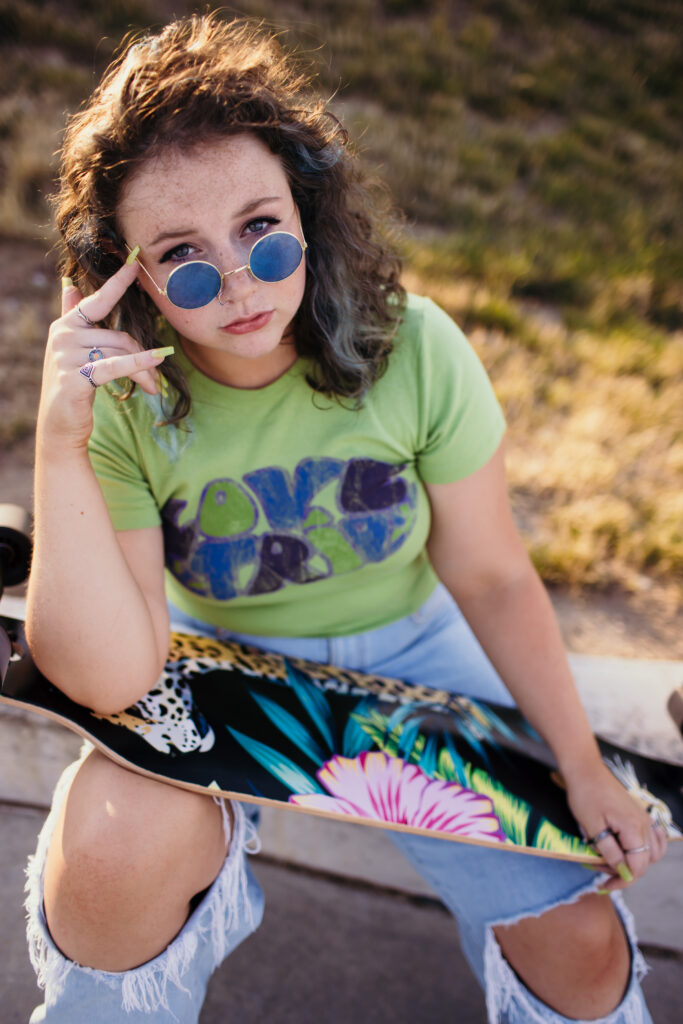 Female senior photos at Kansas City skate park with skateboard and casual style