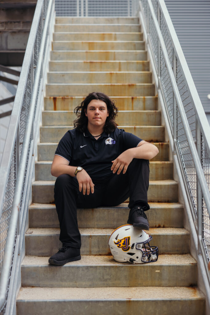 High school senior guy portraits with football helmet in Kansas City city setting