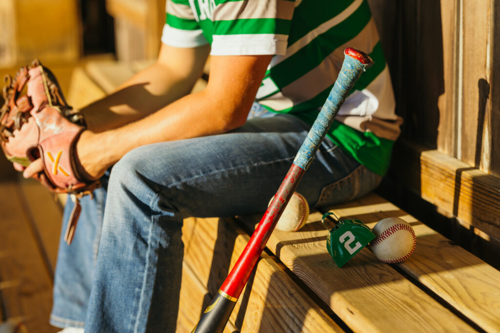 Kansas City baseball senior session featuring player in dugout with gear