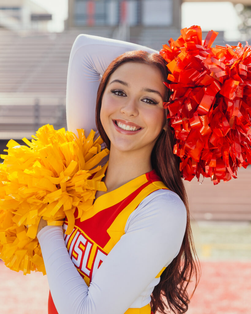 High school senior girl in cheer uniform on field for Kansas City senior portraits