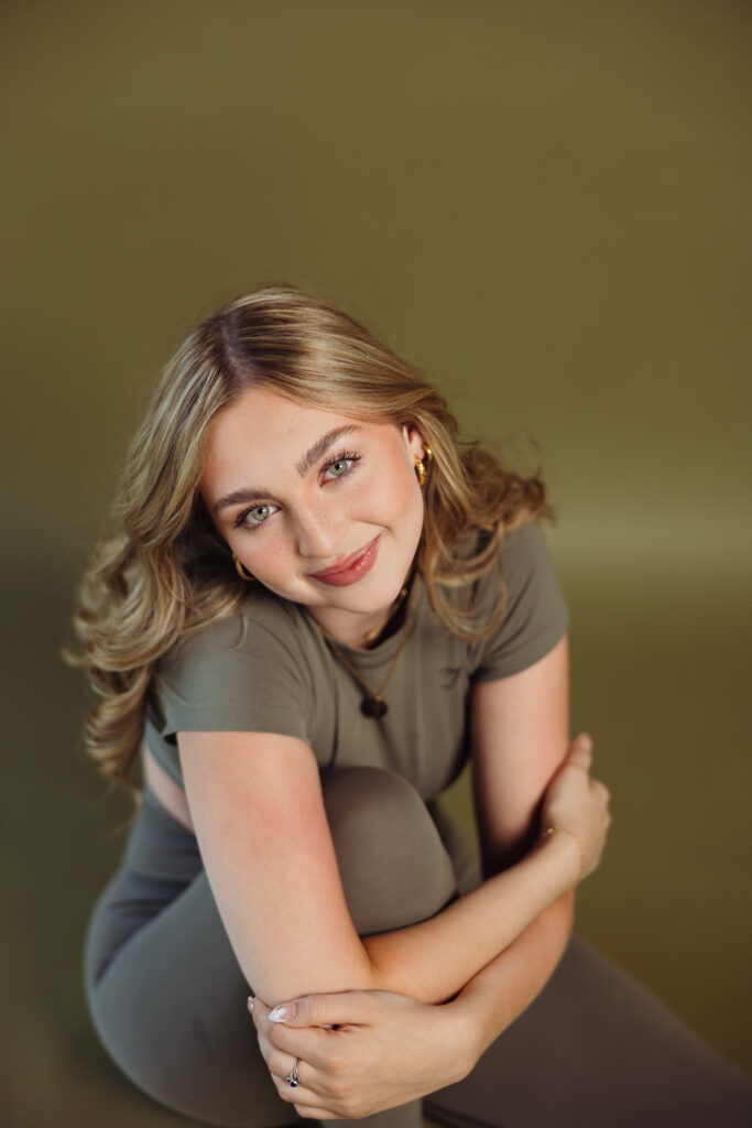 Kansas City high school senior photographed on green backdrop in the studio