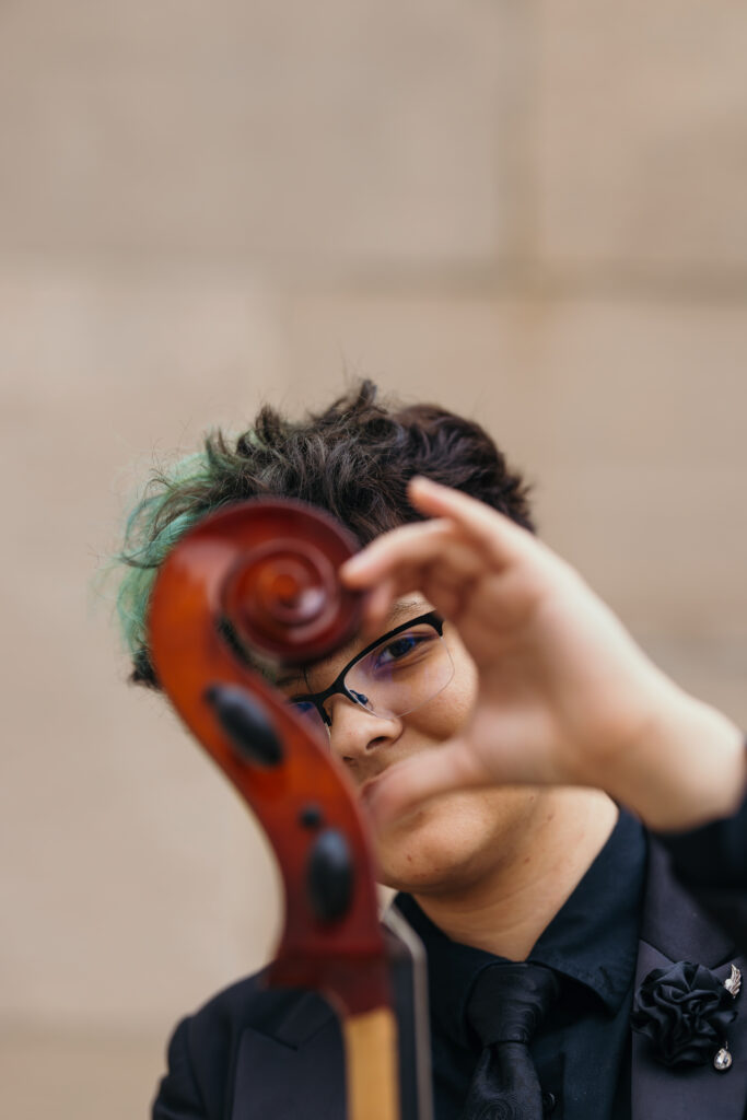 Kansas City high school senior posing with cello at Liberty Memorial during senior photo session