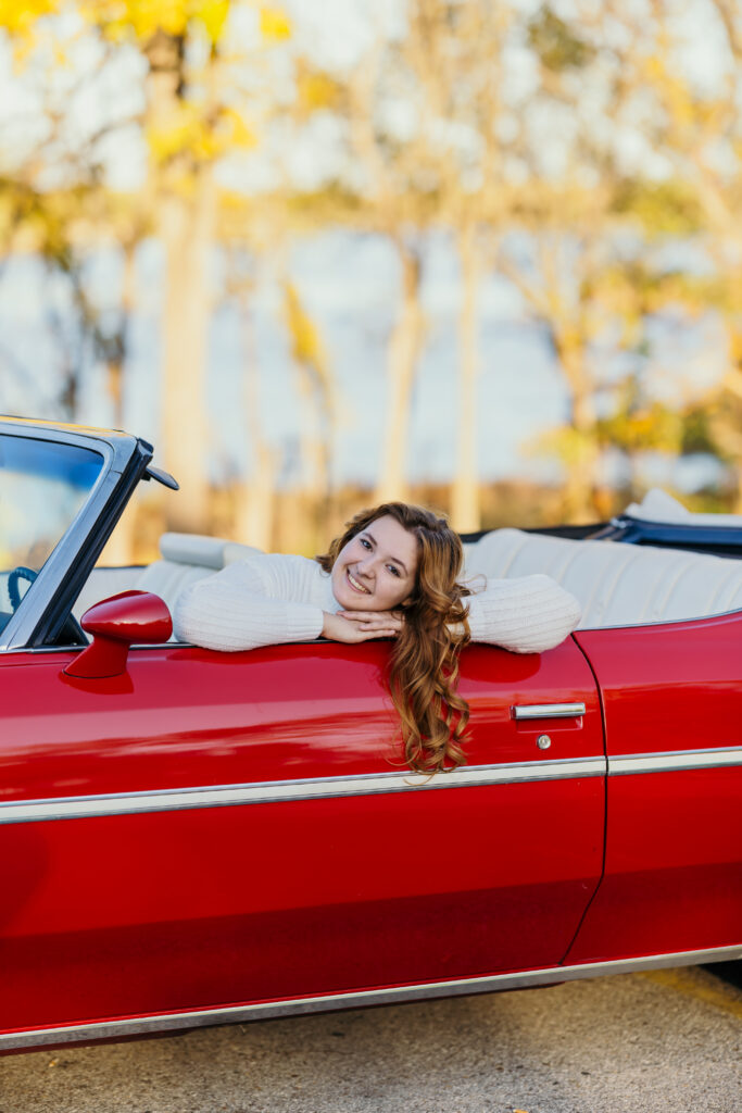 Stylish high school senior girl with convertible car in senior portraits