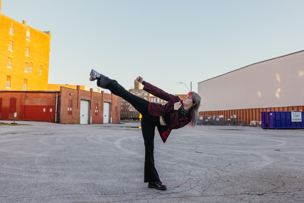 Senior girl showcasing martial arts skills in urban Kansas City setting