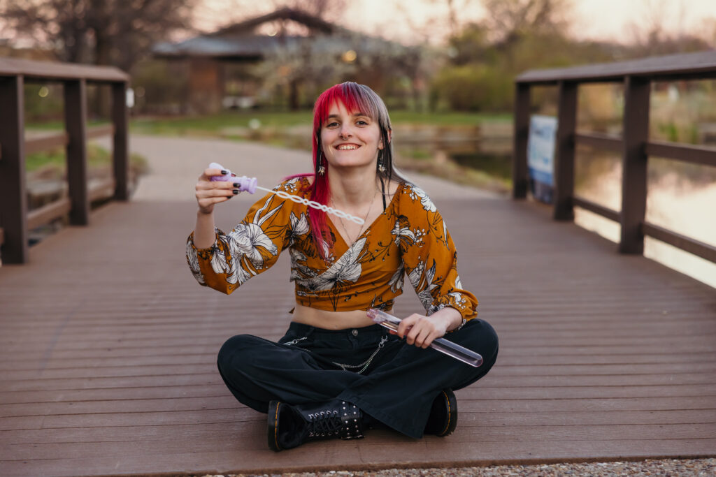Kansas City senior blowing bubbles during senior photography session