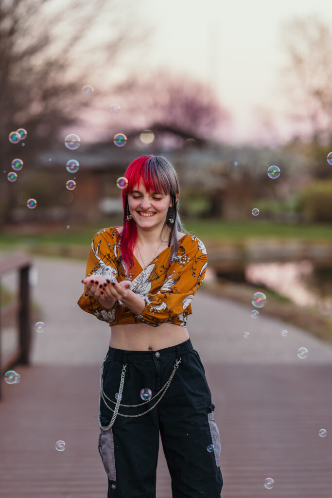 Candid senior photo with bubbles at golden hour in Kansas City