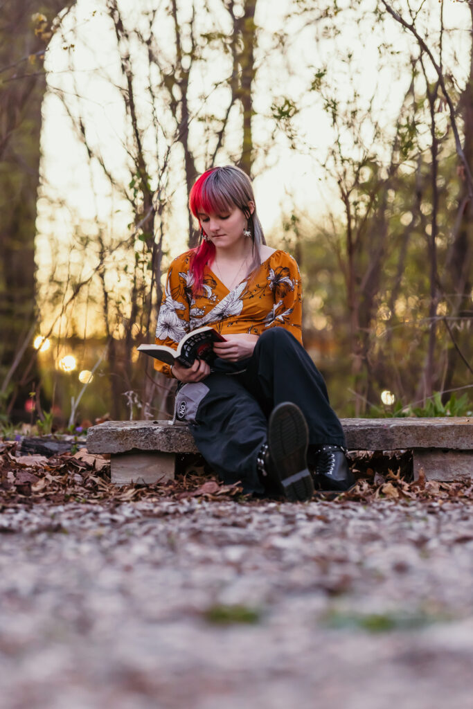 Kansas City senior girl posing with book in a nature setting