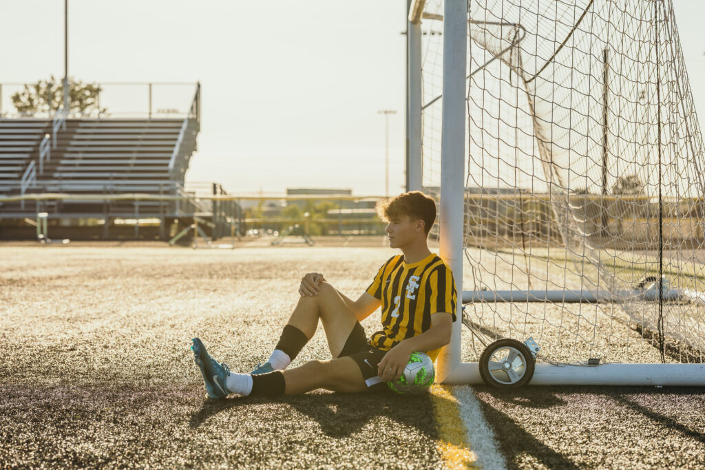 Male senior athlete with soccer ball on Kansas City field at sunset