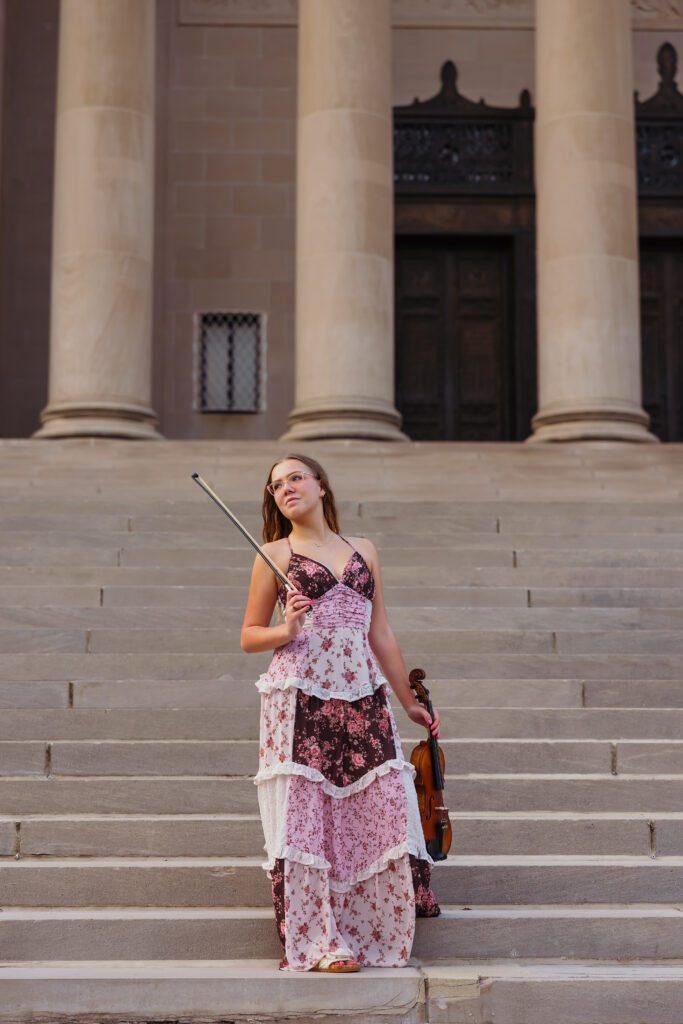 Kansas City high school senior girl posing with violin at Nelson-Atkins Museum during senior photo session