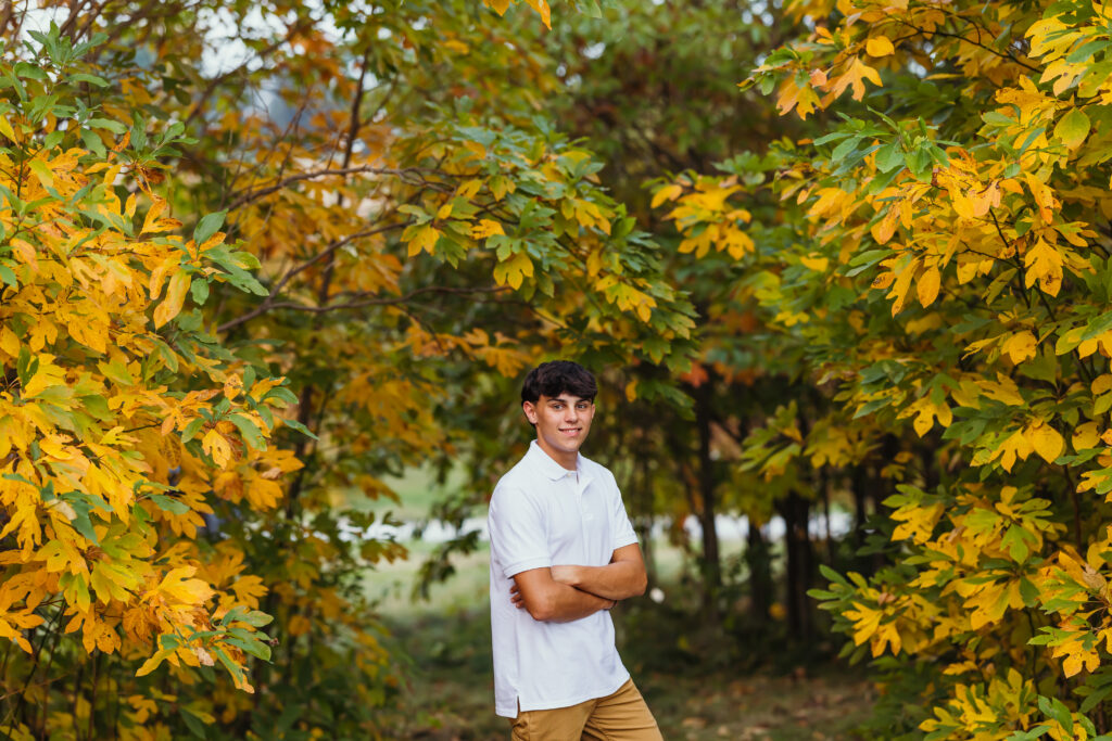 Senior boy fall photo session with colorful autumn leaves