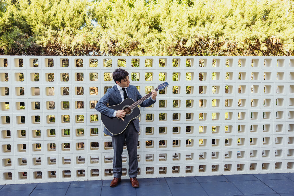 High school senior playing acoustic guitar during outdoor senior photos