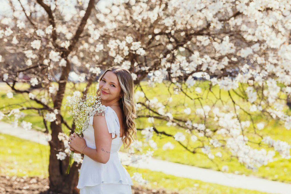 High school senior girl surrounded by flowers in outdoor portraits