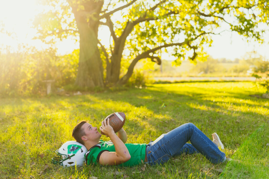 High school senior boy playing football during his session