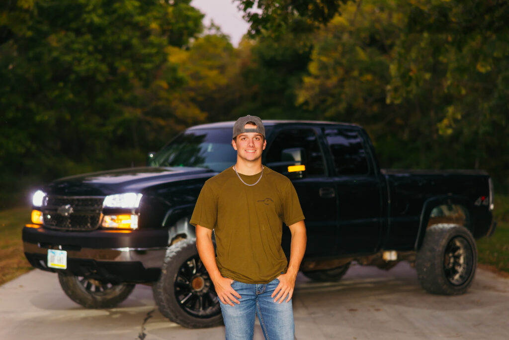 High school senior boy with his pickup truck during senior photos