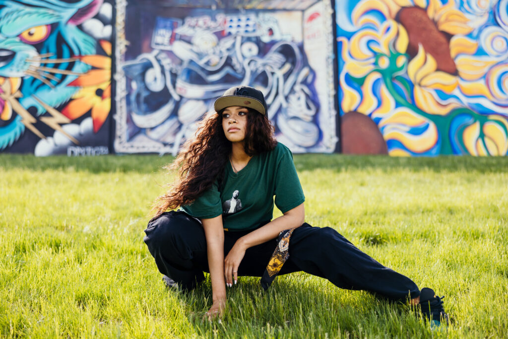 High school senior posing with graffitti mural