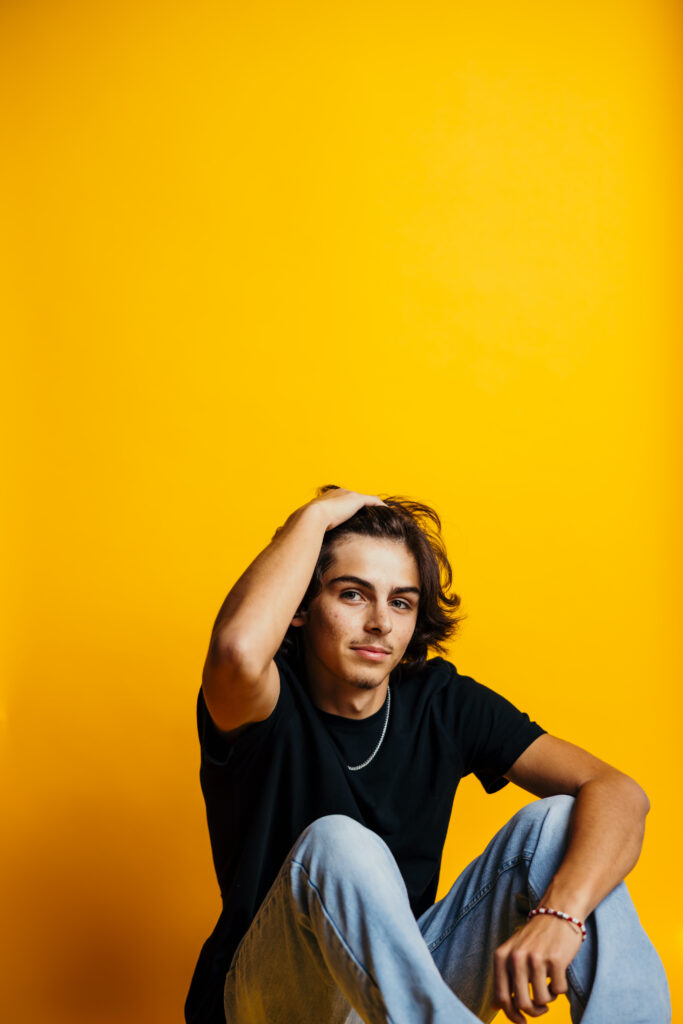 High school senior boy studio session with yellow background