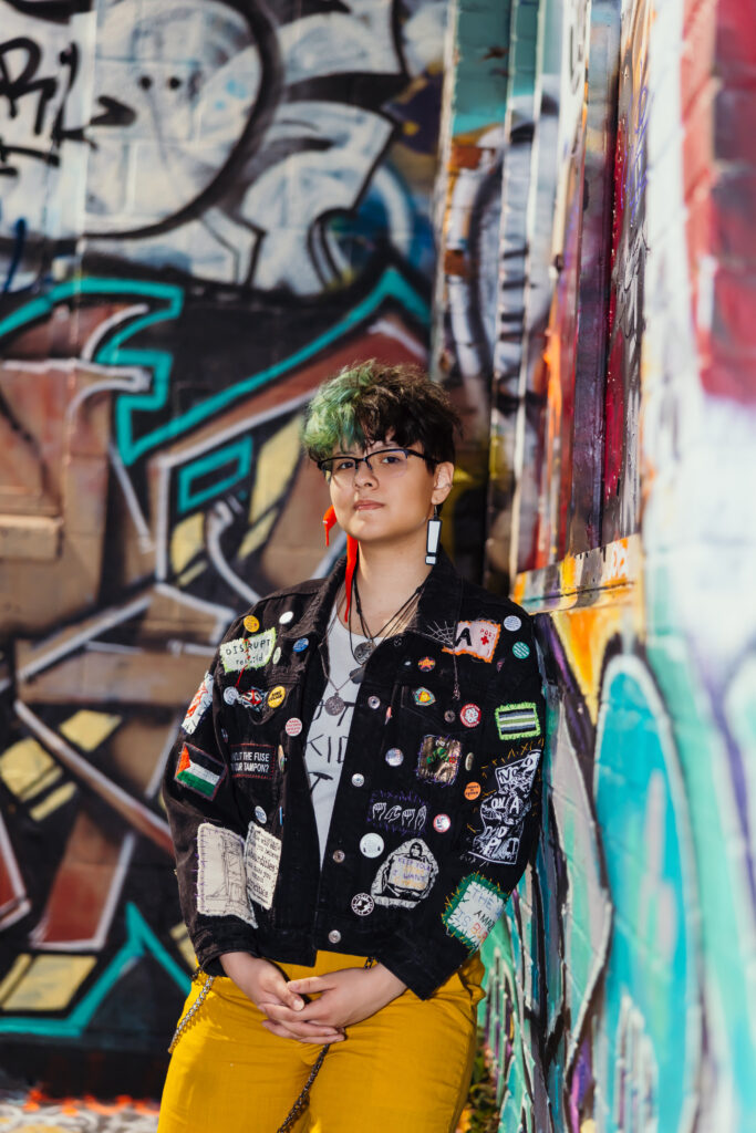 High school senior girl photoshoot in the Crossroads downtown Kansas City with graffiti and patch jacket