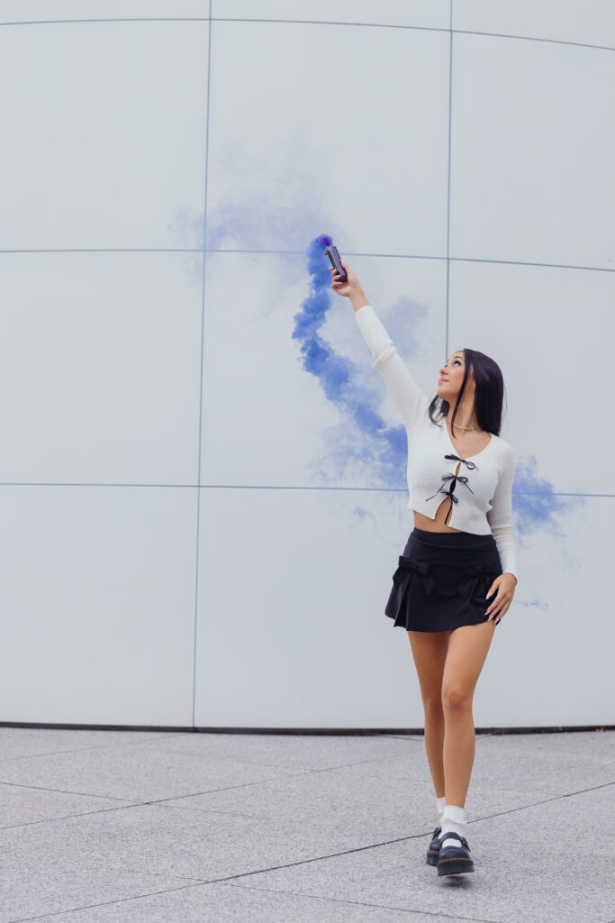 High school senior in black and white outfit with smoke bomb