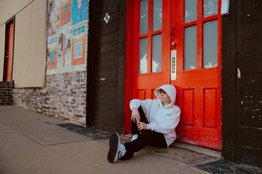 High school senior boy in hoodie in urban location
