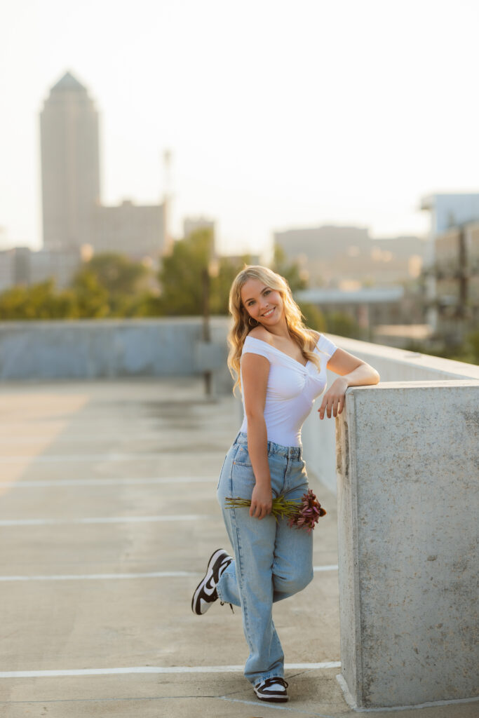 High school senior golden hour rooftop with flowers in a casual outfit