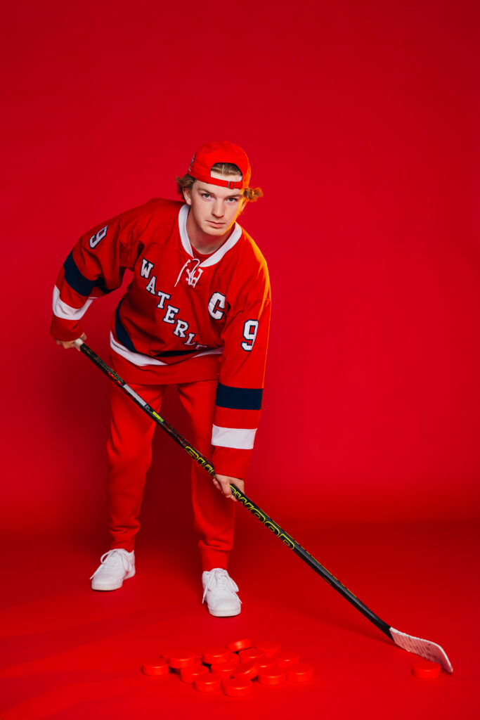 High school senior red studio photo session showing off hockey