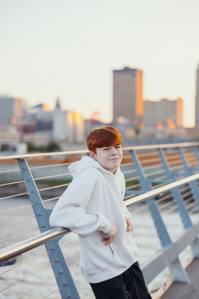 High school senior boy on a bridge at golden hour