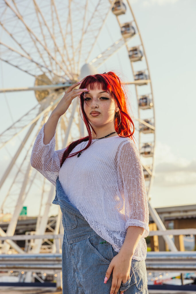 Kansas City high school senior posing with KC ferris wheel in downtown Kansas City