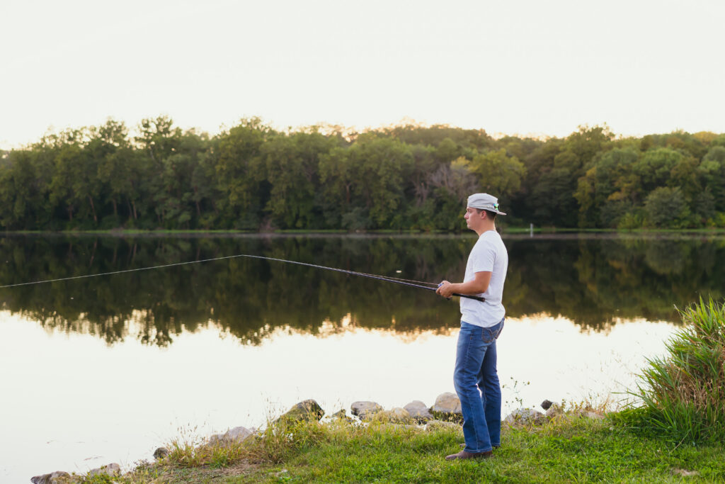 High school senior fishing at a lake during senior session