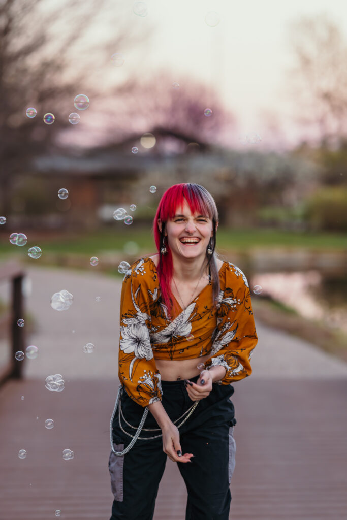 High school senior playing with bubbles during senior photos
