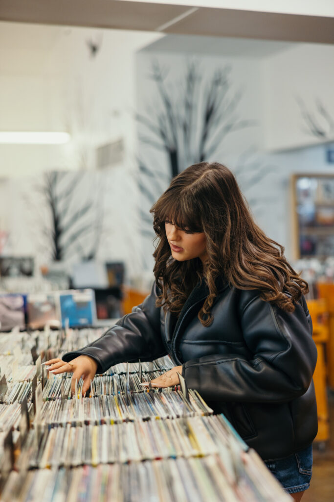 Senior girl searching through music records during senior session in Kansas City