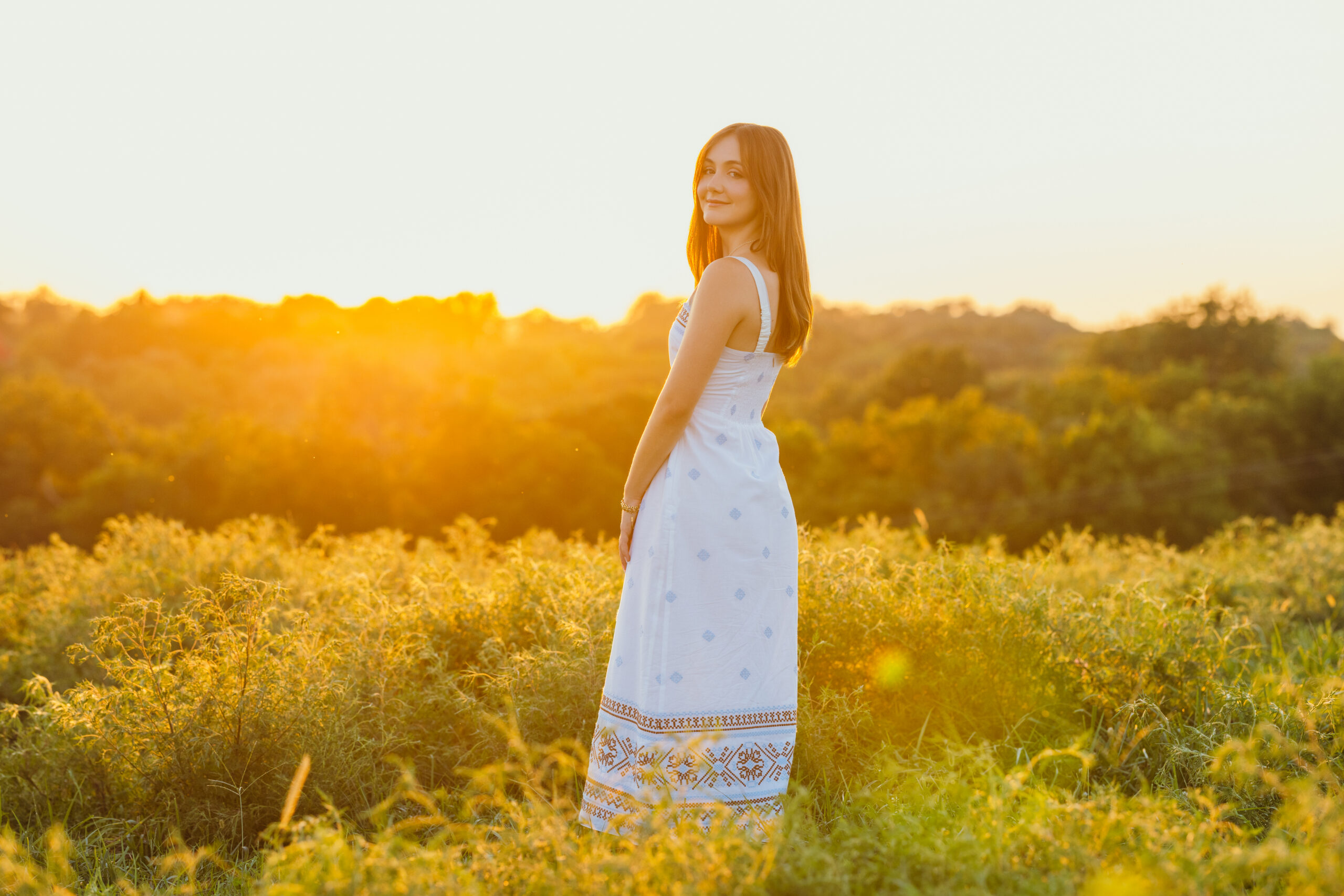 High school senior in a field at golden hour near Kansas City