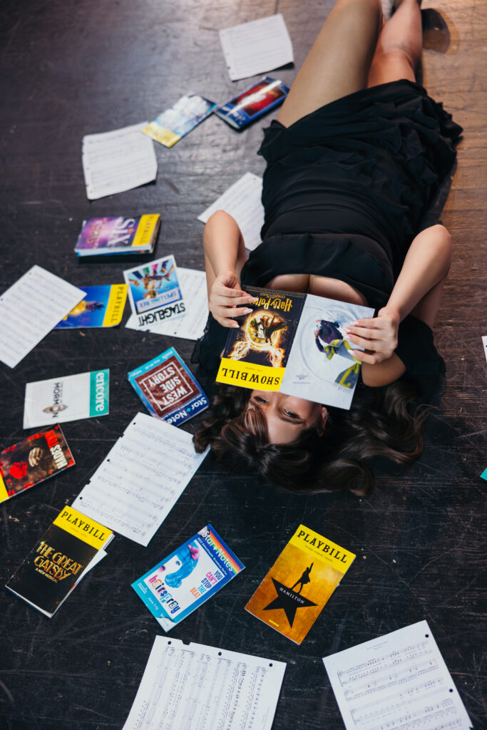 High school senior posing with playbills during senior session