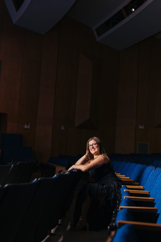 Kansas City senior photos celebrating her love of music and theater in her high school auditorium